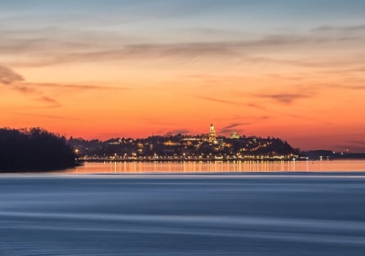 Wide view of Belgrade, Serbia, at sunset with city lights reflecting on the water
