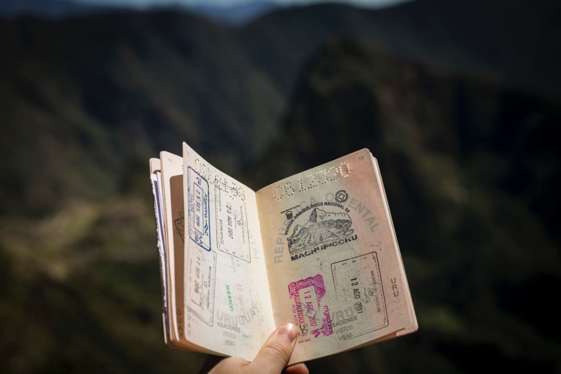 Hand holding open passport with a Turkish visa for US citizens