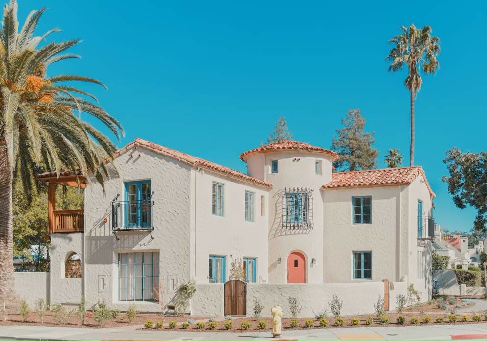 A white house in Spain with palm trees around it.