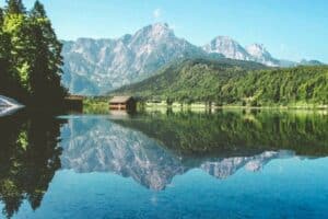Mirrored reflection in an Austrian lake with mountains in the background - crypto-friendly places in the world