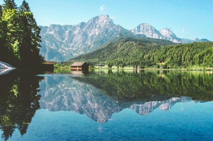 Mirrored reflection in an Austrian lake with mountains in the background - crypto-friendly places in the world