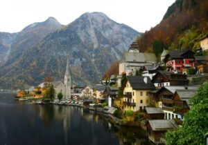 Historic Austrian houses on a lakeside with a mountain in the background - best CBI programs in Europe