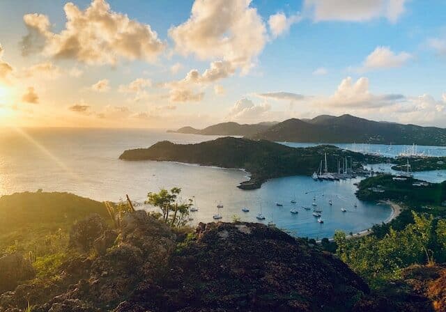 Green hilltop next to ocean in Antigua and Barbuda at sunset - citizenship easiest route