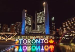 Skyscrapers in Canada with a glowing Toronto sign in front.