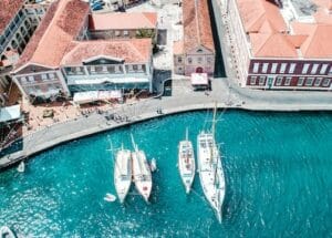 Aerial view of white boats docked near old-fashioned houses dotted the shoreline in Grenada - welcoming countries for expats