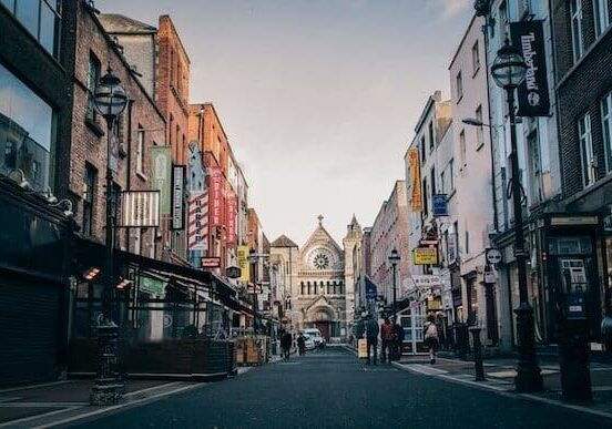 Old buildings in Ireland lining a street with people walking through - Ireland as a retirement option