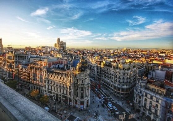 Aerial view of Gran Vía in Madrid, Spain, featuring historic architecture, bustling streets, and a vibrant cityscape under a bright blue sky - buy an EU passport