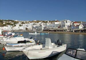 Boats moored in Greece with white buildings in the background - best European countries to retire in