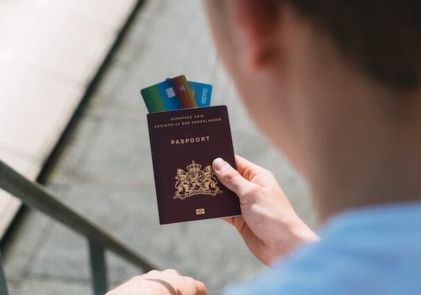 Man holding passport and credit cards - dual nationality