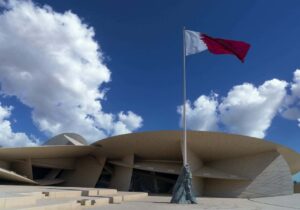 Qatar flag waving in the wind - Middle Eastern country with no taxes for capital gains