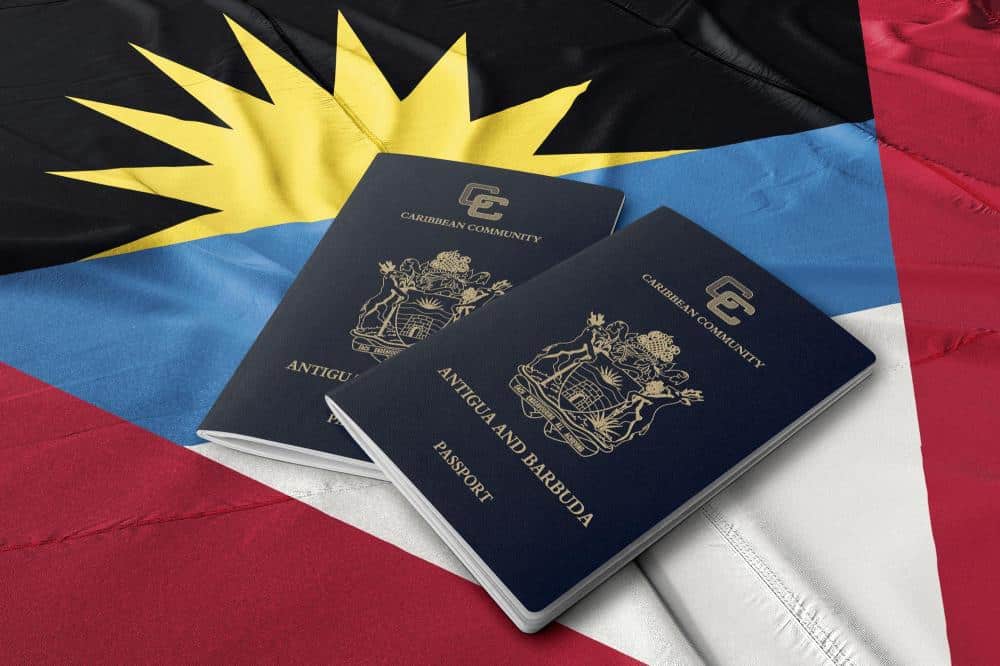 two antigua passports on an antiguan and barbudan flag