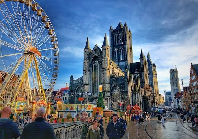 Ghent city historical center with Saint Nicholas Church on Korenmarkt Wheat Market square, Belfry Het Belfort van Gent and row of colorful buildings in Flemish Region, Belgium - citizenship by marriage