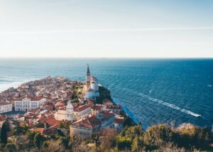 Brown roof buildings in a village in Piran, Slovenia overlooking the ocean - one of the highest taxes in the EU