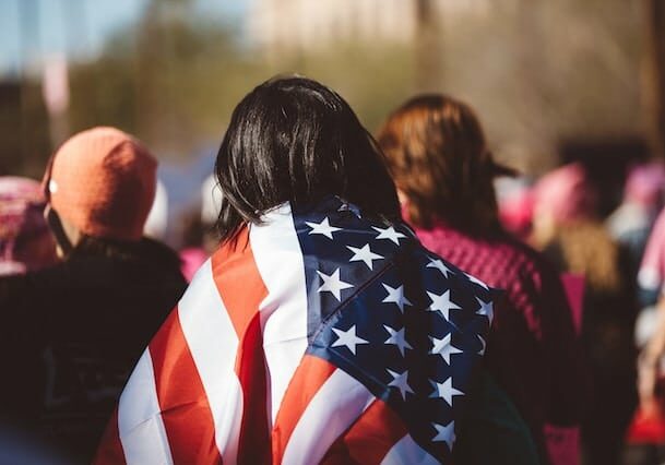 woman wearing a us flag in a crowd