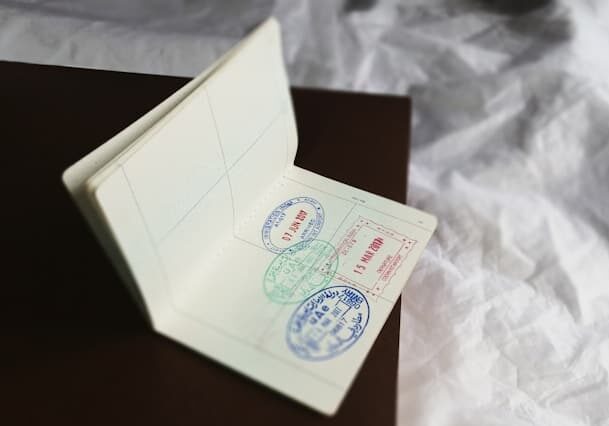 Passport with stamps open on a black book and a white linen sheet in the background - buying a second home abroad
