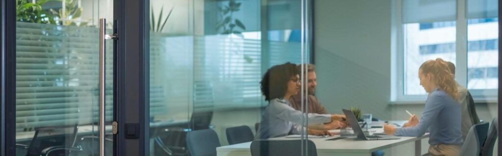 office in Grenada with a glass an workers sitting at a table