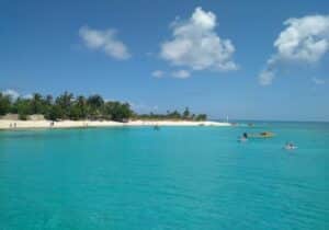 View of ocean shoreline in Vanuatu with swimmers in the water - fastest Caribbean citizenship by investment