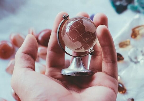 Hand holding a transparent globe - introducing the benefits of low-tax countries