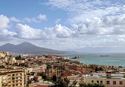 View of Naples in Italy on a partly cloudy day with the sea in the background - move out of the USA permanently