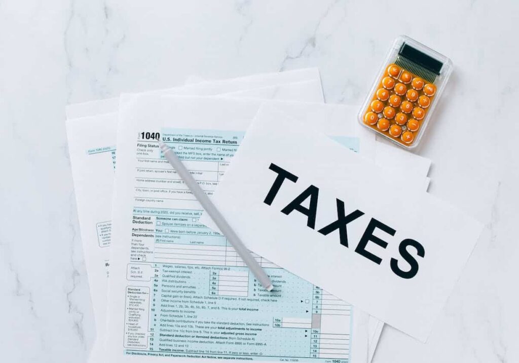 Flat lay of documents, a calculator and a printout saying "taxes" - strategies for avoiding taxes related to inheritance