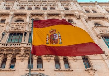 Spain flag waving in front of a government building - easiest countries to get residency