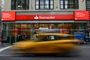 View of Santander bank with a yellow car driving by in a blur - best banks in the world