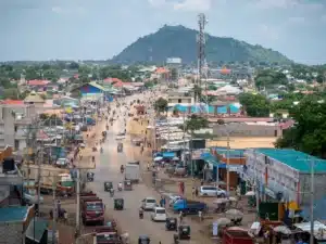 Aerial view of a city in South Sudan with hill in the background and people walking - Fastest-growing economy
