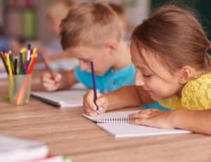 children writing in notebooks as part of the Canadian education system
