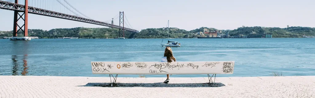 Woman sited by the Tagus river in Lisbon, Portugal