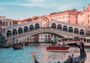 Bridge in Italy with gondolas in the foreground - Italy as one of the best countries to live in for expats