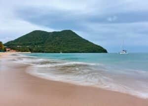 st lucia beach with mountains and a boat in the distance