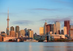 city in Canada with tall buildings and blue sky by a waterfront