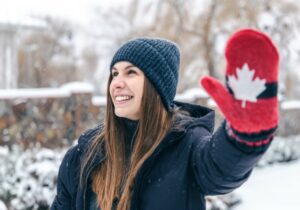 woman with a hand holding Canadian flag on a glove in winter