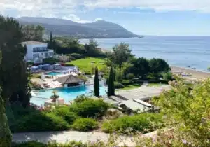 View of a resort in Cyprus with a swimming pool and lush green trees - Cyprus Golden Visa for students