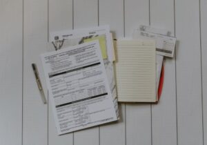 Top view of documents, a notebook and pen on a white background - Countries with No Property Tax