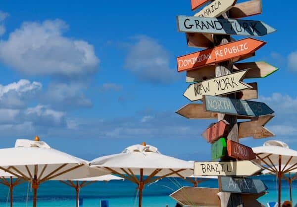 Directional pole showing various cities on the beach in Turks and Caicos - no property taxes