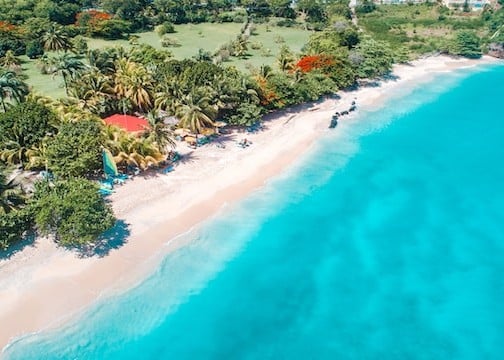 Shoreline in Grenada dotted by private houses and beach chairs - no taxes on property purchases