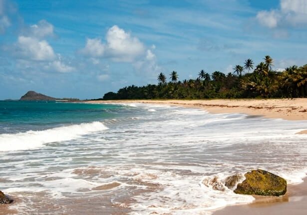 Beach in Grenada on a partly cloudy day - Caribbean countries Americans are moving to