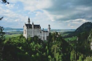 Neuschwanstein Castle in Schwangau, Germany wit trees in the foregound - Germany as one of the best countries for healthcare