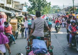 View of a man's on a colorful bike navigating traffic in Indonesia - Asian country welcoming to digital nomads