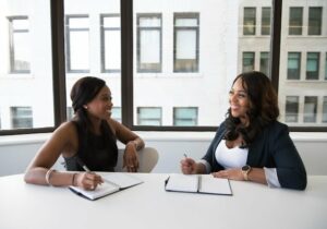 Two woman sitting at a desk in an office - 16 Best English-Speaking Countries