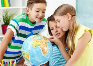 Children looking at a earth globe on table