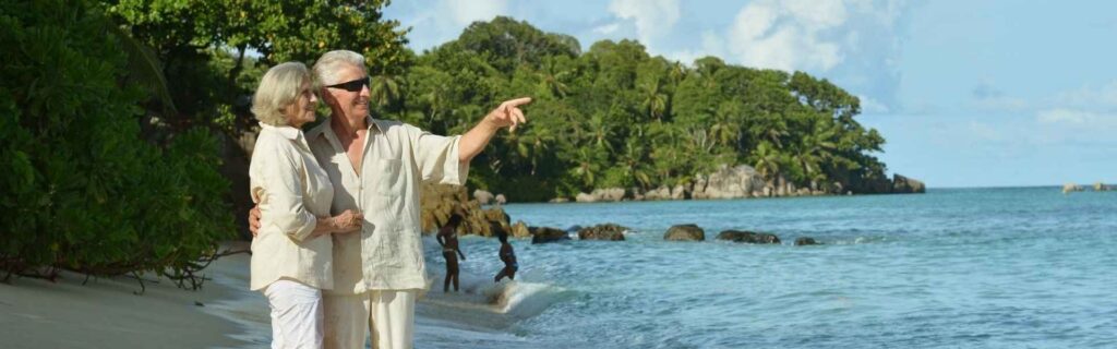 a retired couple looking out to the sea on a beach in st lucia