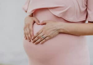 pregnant woman holding stomach representing Latvian Citizenship by descent 