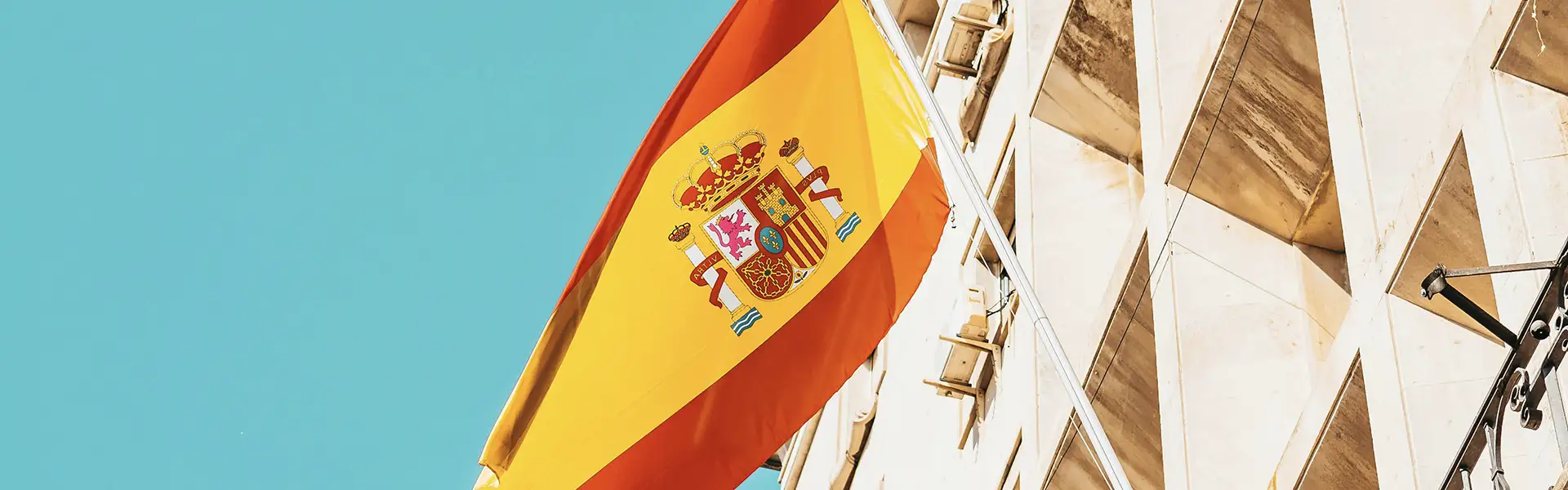 spanish flag on a building over a blue sky