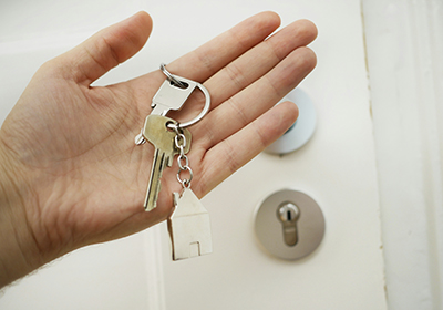 A person holding up a house key. 
