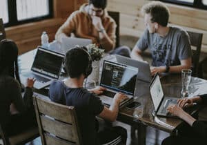 Five people on laptops at one desk investing in Turkey 