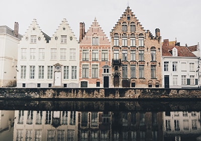 Row of old-fashioned brick houses in Belgium alongside a river - one of the least racist EU countries