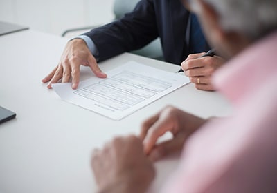 lawyer signing documents on a table as part of the dominica citizenship process