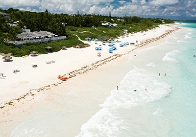 Beach in the Bahamas on a sunny day with a resort and umbrellas - top tax-free countries